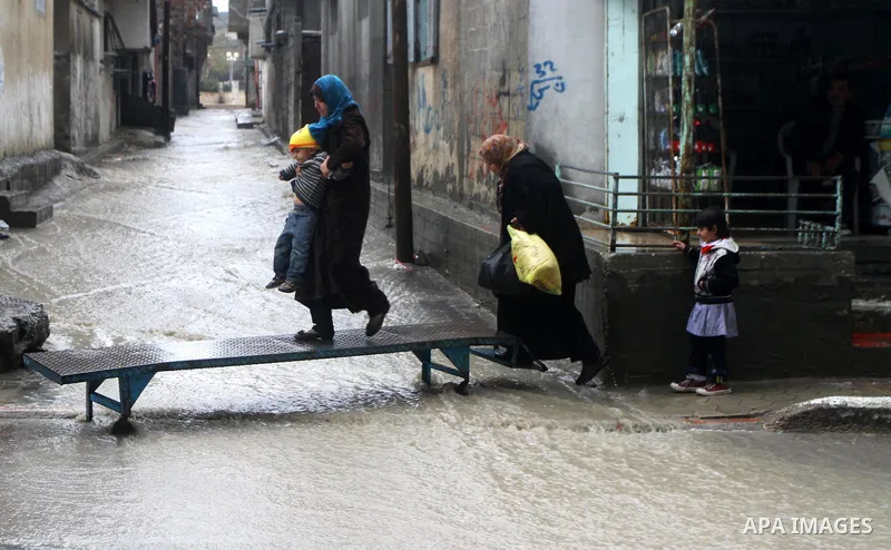 Palestinians walk in a street during the heavy rain of the winter, in the Gaza City, Feb. 01, 2012. Photo by Ashraf Amra