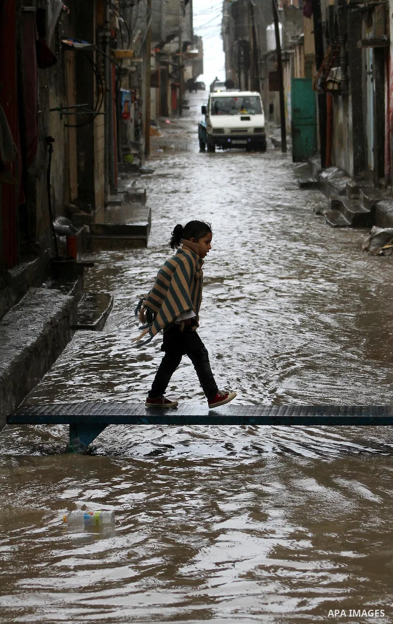 Palestinians walk in a street during the heavy rain of the winter, in the Gaza City, Feb. 01, 2012. Photo by Ashraf Amra