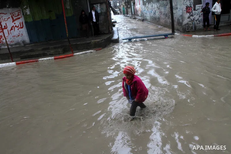 Palestinians walk in a street during the heavy rain of the winter, in the Gaza City, Feb. 01, 2012. Photo by Ashraf Amra