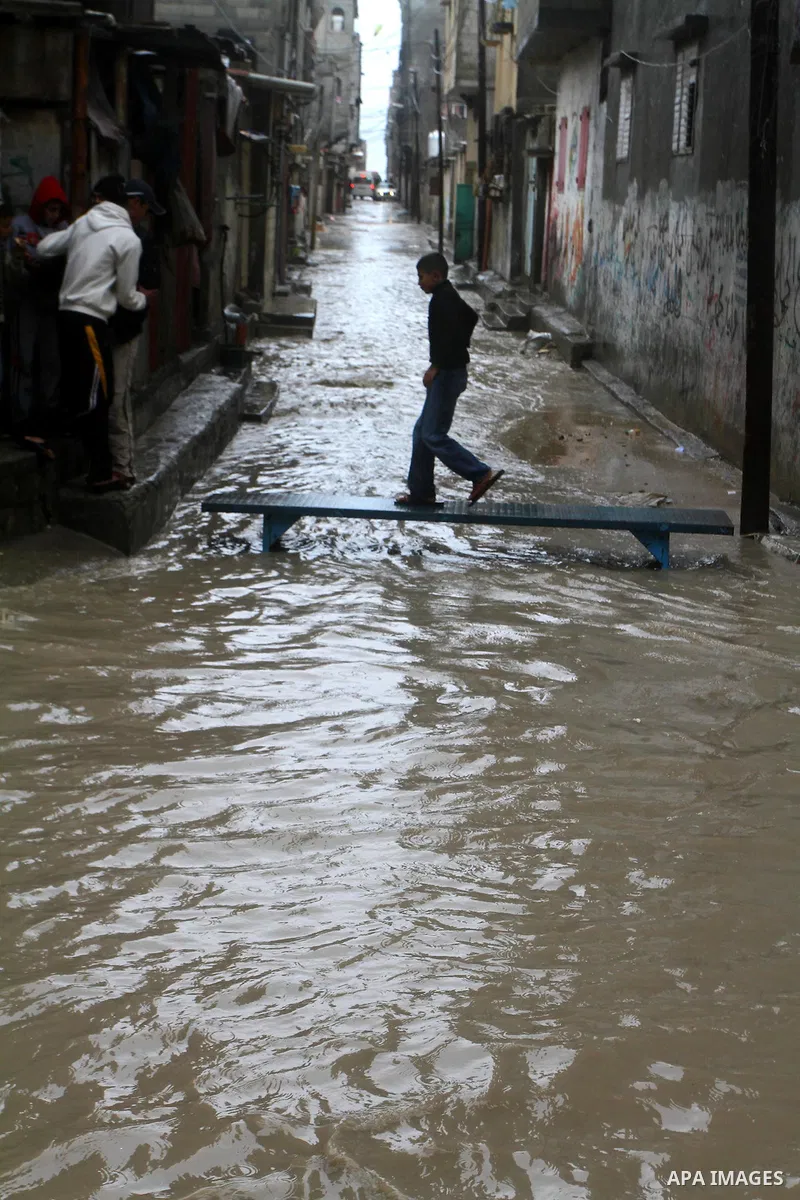 Palestinians walk in a street during the heavy rain of the winter, in the Gaza City, Feb. 01, 2012. Photo by Ashraf Amra
