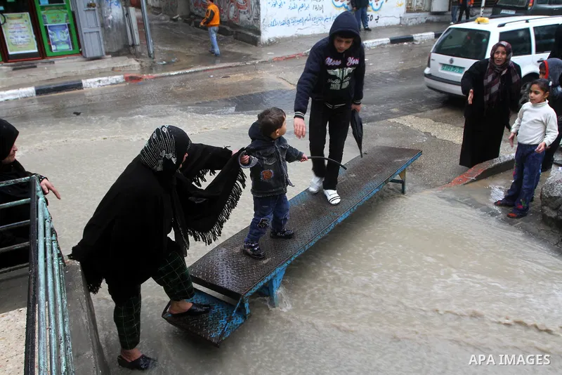 Palestinians walk in a street during the heavy rain of the winter, in the Gaza City, Feb. 01, 2012. Photo by Ashraf Amra