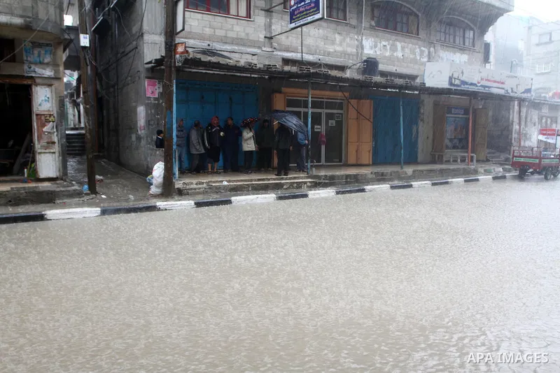 Palestinians walk in a street during the heavy rain of the winter, in the Gaza City, Feb. 01, 2012. Photo by Ashraf Amra