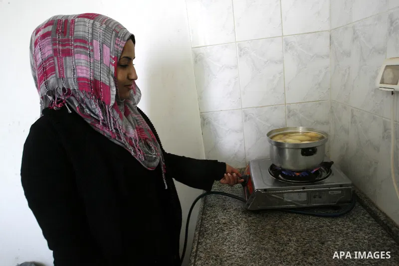 A Palestinian family prepares Bread traditional from Potatoes, at their house in town of Khan Yunis, southern Gaza Strip on February 2, 2012. Palestinian families used some of the manufacture of potato bread instead of t...