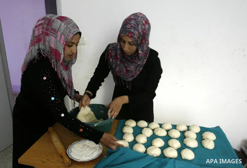 A Palestinian family prepares Bread traditional from Potatoes, at their house in town of Khan Yunis, southern Gaza Strip on February 2, 2012. Palestinian families used some of the manufacture of potato bread instead of t...