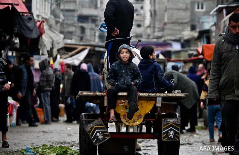 Palestinian children play in front of shop at the old Fras market during the heavy rain of the winter in Gaza city on Feb. 02, 2012. Photo by Ali Jadallah