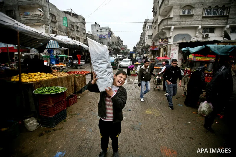 Palestinian children play in front of shop at the old Fras market during the heavy rain of the winter in Gaza city on Feb. 02, 2012. Photo by Ali Jadallah