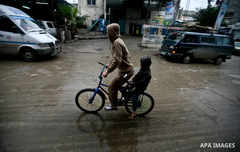 Palestinian children walk in a street during the heavy rain of the winter, in the Gaza City, Feb. 01, 2012. Photo by Ali Jadallah