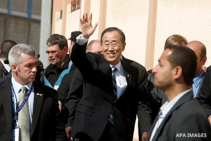 UN secretary general Ban Ki-moon waves during a visit to the construction site of a housing project in Khan Yunis in the southern Gaza Strip on February 2, 2012. Protesters threw shoes, sand and small stones at the convo...