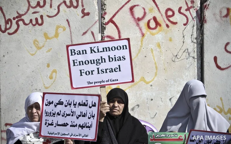 Palestinians demonstrate before the arrival of UN Secretary-General Ban Ki-moon at the Erez checkpoint in the northern Gaza Strip on February 2, 2012. Protesters threw shoes, sand and small stones at his convoy, which wa...