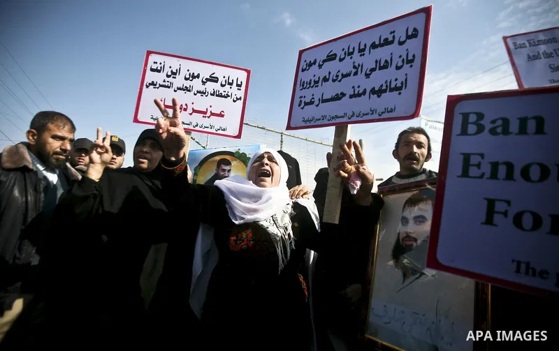 Palestinians demonstrate before the arrival of UN Secretary-General Ban Ki-moon at the Erez checkpoint in the northern Gaza Strip on February 2, 2012. Protesters threw shoes, sand and small stones at his convoy, which wa...