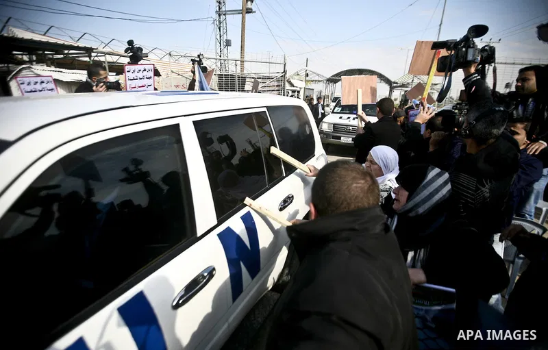 Relative of Palestinian prisoners in Israeli jails use wooden sticks to hit a vehicle in the convoy of UN Secretary-General Ban Ki-moon as it arrives at the Erez checkpoint in the northern Gaza Strip on February 2, 2012....