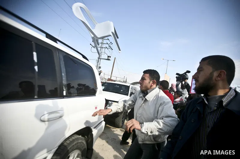 Relative of Palestinian prisoners in Israeli jails use wooden sticks to hit a vehicle in the convoy of UN Secretary-General Ban Ki-moon as it arrives at the Erez checkpoint in the northern Gaza Strip on February 2, 2012....
