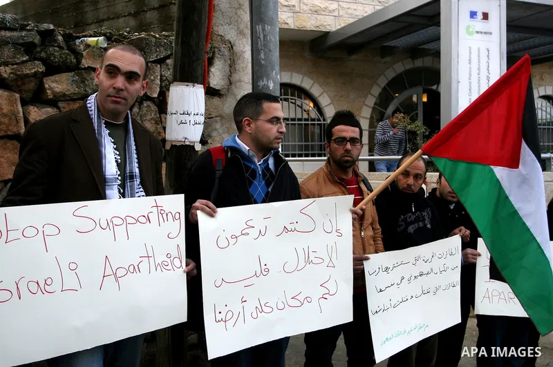 Palestinians hold banners during a demonstration in front of the French Cultural Center in the West Bank city of Ramallah on February 2, 2012, to protest against the drones deal that France intends to purchase from Israe...