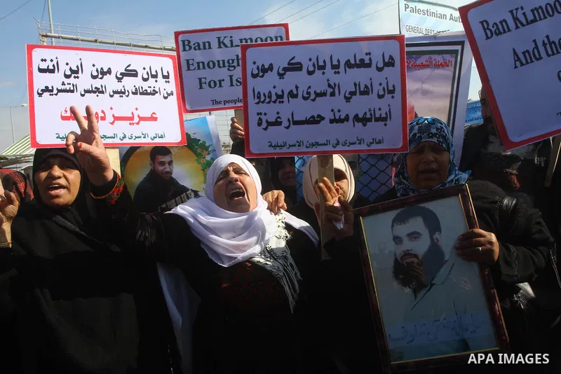 Palestinians demonstrate before the arrival of UN Secretary-General Ban Ki-moon at the Erez checkpoint in the northern Gaza Strip on February 2, 2012. Protesters threw shoes, sand and small stones at his convoy, which wa...