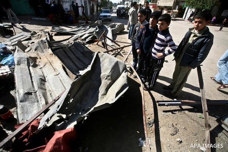 Palestian boys stand next to a destroyed house after an Israeli airstrike in Beit Lahiya town in the northern Gaza Strip, 03 February 2012. Two Palestinians were wounded by Israeli air-strikes in the Gaza Strip. . Photo...