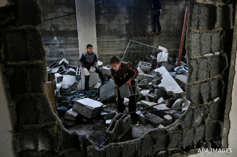 Palestian boys stand next to a destroyed house after an Israeli airstrike in Beit Lahiya town in the northern Gaza Strip, 03 February 2012. Two Palestinians were wounded by Israeli air-strikes in the Gaza Strip. . Photo...