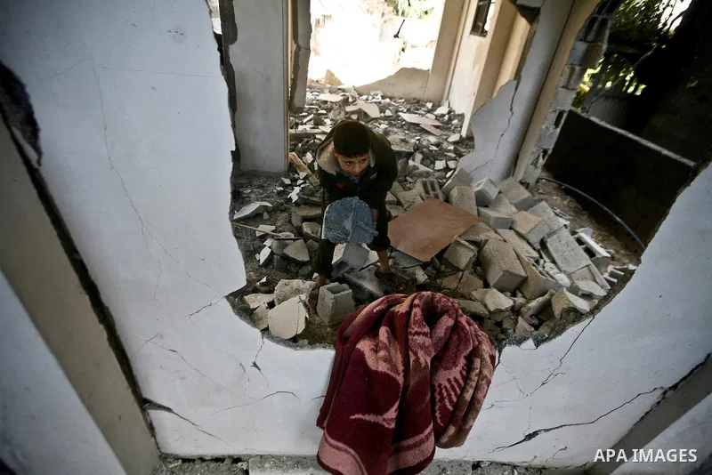 Palestian boys stand next to a destroyed house after an Israeli airstrike in Beit Lahiya town in the northern Gaza Strip, 03 February 2012. Two Palestinians were wounded by Israeli air-strikes in the Gaza Strip. . Photo...