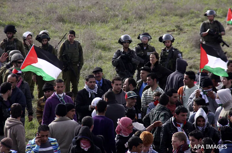 Palestinians holds national flag, during a protest in the Village Qaryut , near the Israeli settlement of Ali, in the northern West Bank, Friday, Feb. 03, 2012. Photo by Wagdi Eshtayah
