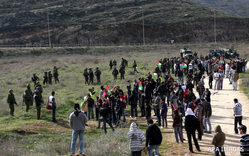 Palestinians holds national flag, during a protest in the Village Qaryut , near the Israeli settlement of Ali, in the northern West Bank, Friday, Feb. 03, 2012. Photo by Wagdi Eshtayah