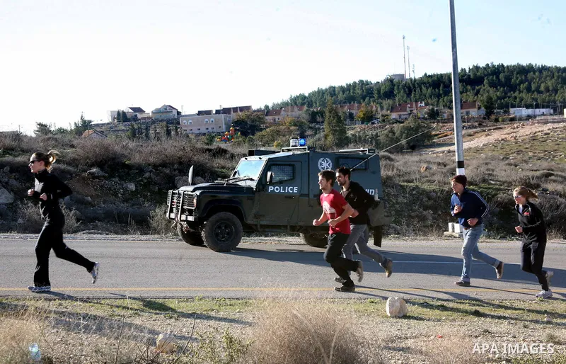 Israeli soldiers block the road in front of Palestinians, Israeli and foreign activists during a marathon to support the farmers and land owners in the West Bank city of Hebron on Feb. 4,2012. Israeli troops detained a P...