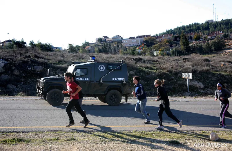 Israeli soldiers block the road in front of Palestinians, Israeli and foreign activists during a marathon to support the farmers and land owners in the West Bank city of Hebron on Feb. 4,2012. Israeli troops detained a P...
