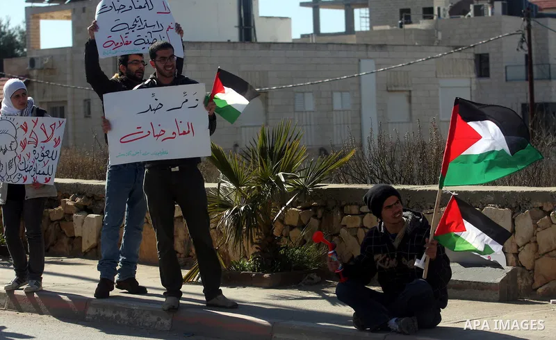 Palestinian activists hold banners during a protest against the peace talks in the West Bank city of Ramallah Saturday, February 4, 2012. Palestinian and Israeli negotiators met last week for the first time in more than...