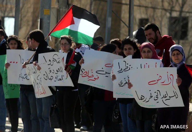 Palestinian activists hold banners during a protest against the peace talks in the West Bank city of Ramallah Saturday, February 4, 2012. Palestinian and Israeli negotiators met last week for the first time in more than...