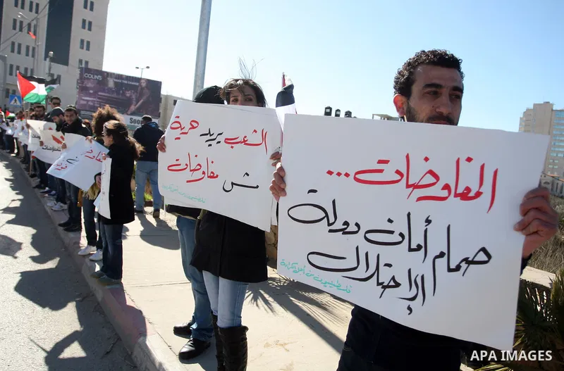 Palestinian activists hold banners during a protest against the peace talks in the West Bank city of Ramallah Saturday, February 4, 2012. Palestinian and Israeli negotiators met last week for the first time in more than...