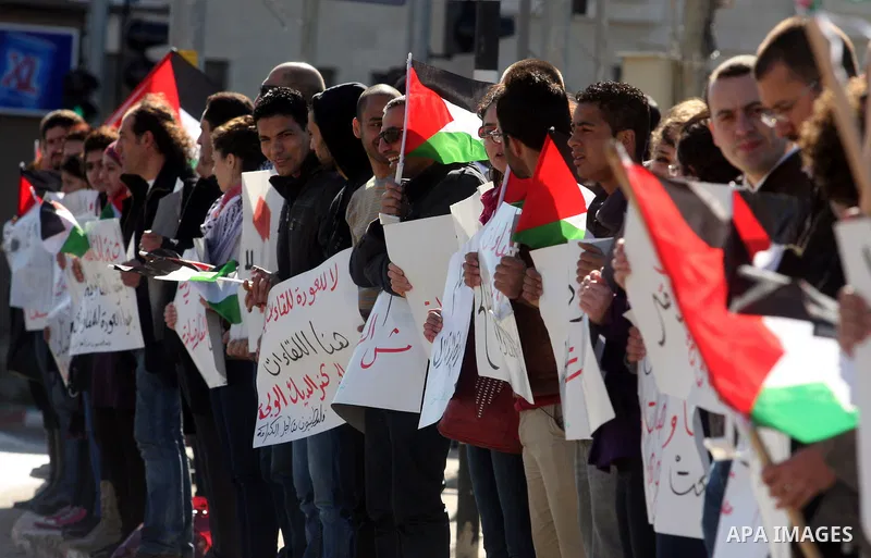 Palestinian activists hold banners during a protest against the peace talks in the West Bank city of Ramallah Saturday, February 4, 2012. Palestinian and Israeli negotiators met last week for the first time in more than...