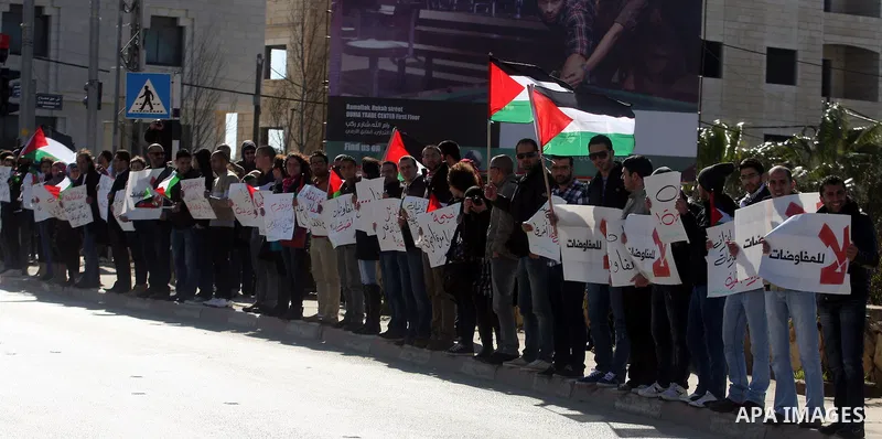 Palestinian activists hold banners during a protest against the peace talks in the West Bank city of Ramallah Saturday, February 4, 2012. Palestinian and Israeli negotiators met last week for the first time in more than...