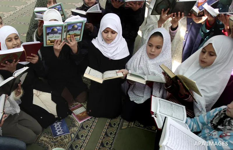 Palestinian Muslim girls read the Quran, as they celebrate the Prophet Muhammad's birthday at a mosque in the Balata refugee camp in the West Bank city of Nablus . Saturday, Feb. 4, 2012. Photo by Wagdi Eshtayah