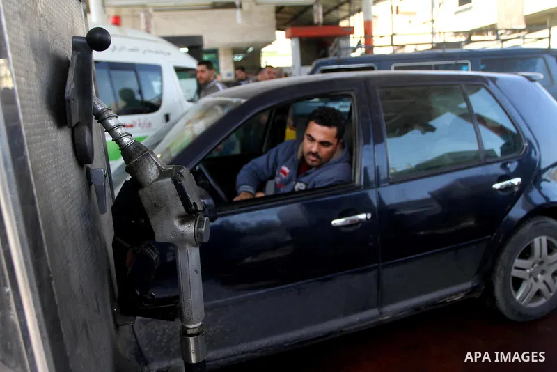 Palestinians wait to fill petrol in containers at a petrol station as a response to the rising price of gasoline in Gaza Strip, on Feb. 05, 2012. Photo by Ashraf Amra
