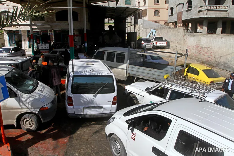 Palestinians wait to fill petrol in containers at a petrol station as a response to the rising price of gasoline in Gaza Strip, on Feb. 05, 2012. Photo by Ashraf Amra
