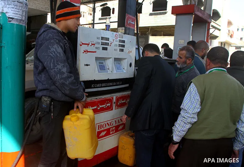 Palestinians wait to fill petrol in containers at a petrol station as a response to the rising price of gasoline in Gaza Strip, on Feb. 05, 2012. Photo by Ashraf Amra
