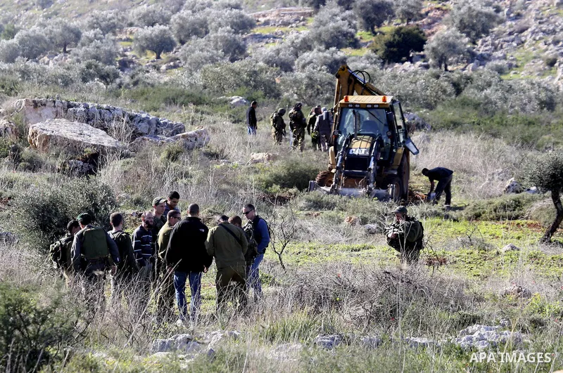 Israeli soldiers stand guards as a bulldozer of the Civil Administration during a demolition in the village of Kufr Qaddum near the Israeli settlement of Kdumim, in the northern West Bank, Sunday, Feb , 05, 2012. Photo b...