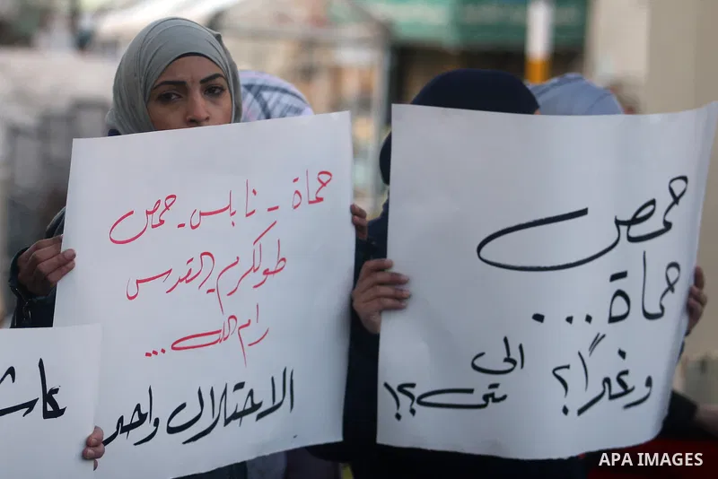 Palestinians hold Syrian flags and signs as they join a demonstration in the West Bank city of Ramallah on Feb 05, 2012. Photo by Issam Rimawi