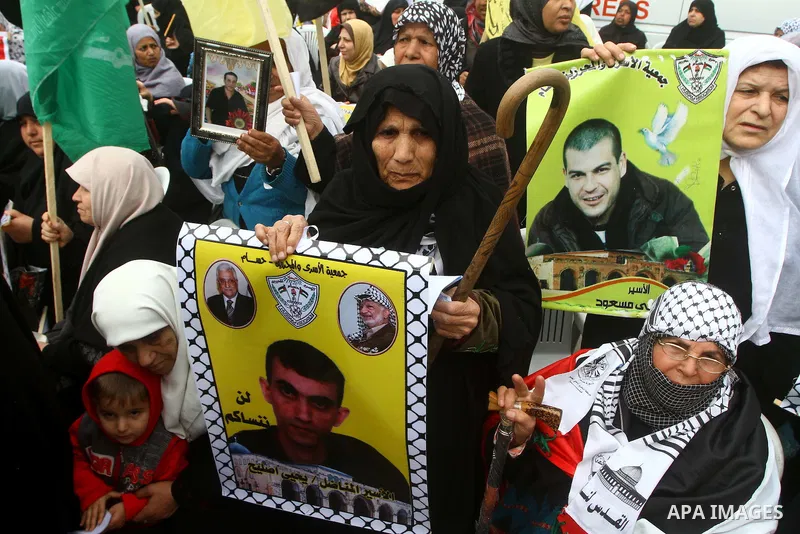 Palestinians hold pictures of their prisoned relatives in Israeli jails as they gather in a weekly activity calling for their liberty at the Red Cross headquarters. 6th February 2012. Photo by Ashraf Amra