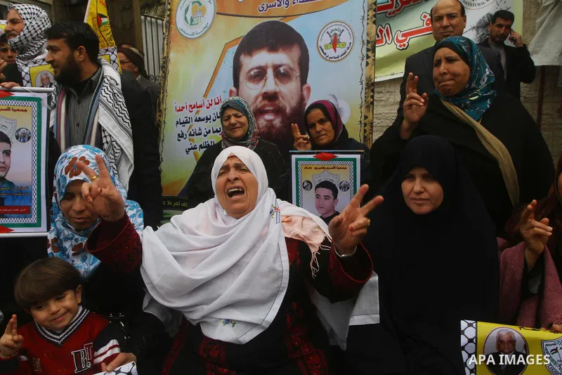 Palestinians hold pictures of their prisoned relatives in Israeli jails as they gather in a weekly activity calling for their liberty at the Red Cross headquarters. 6th February 2012. Photo by Ashraf Amra