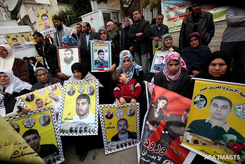 Palestinians hold pictures of their prisoned relatives in Israeli jails as they gather in a weekly activity calling for their liberty at the Red Cross headquarters. 6th February 2012. Photo by Ashraf Amra