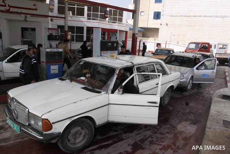 Palestinians wait to fill petrol in containers at a petrol station as a response to the rising price of gasoline in Gaza Strip, on Feb. 06, 2012. Photo by Mohammed Asad