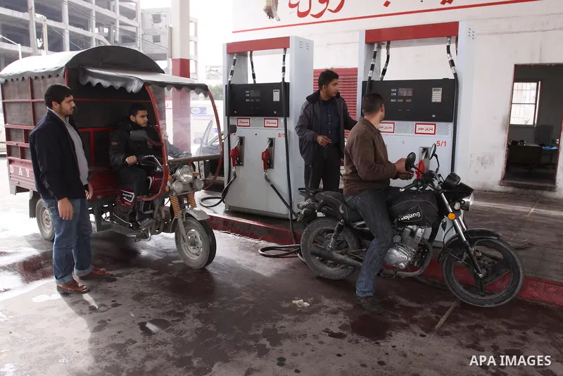 Palestinians wait to fill petrol in containers at a petrol station as a response to the rising price of gasoline in Gaza Strip, on Feb. 06, 2012. Photo by Mohammed Asad