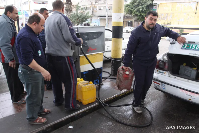 Palestinians wait to fill petrol in containers at a petrol station as a response to the rising price of gasoline in Gaza Strip, on Feb. 06, 2012. Photo by Mohammed Asad