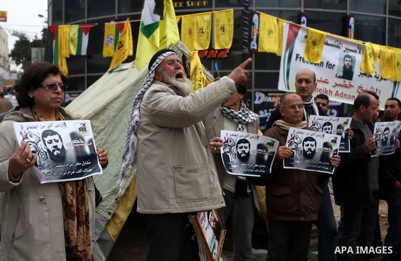 Palestinians hold images of prisoner Khader Adnan, who has been on hunger strike since December 18 while being held in an Israeli jail, during a protest in the West Bank city of Ramallah on February 6, 2012. Adnan, repor...