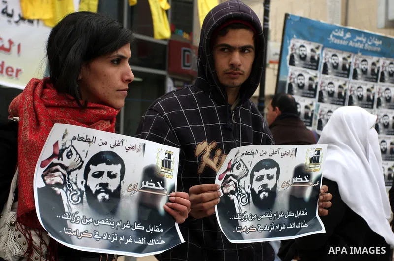 Palestinians hold images of prisoner Khader Adnan, who has been on hunger strike since December 18 while being held in an Israeli jail, during a protest in the West Bank city of Ramallah on February 6, 2012. Adnan, repor...