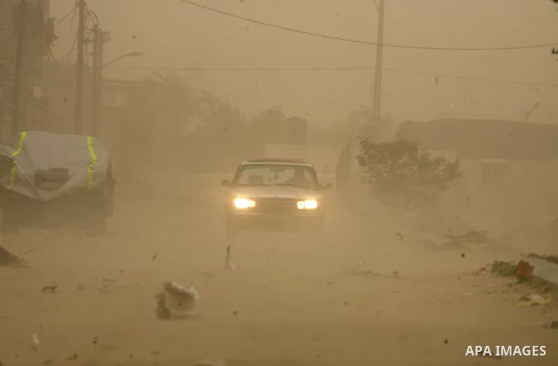 Palestinians walk at a street during cold winds and sand storms in the southern Gaza Strip town of Rafah on February 7, 2012. Photo by Abed Rahim Khatib