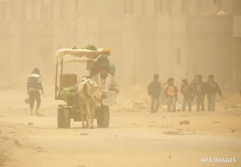 Palestinians walk at a street during cold winds and sand storms in the southern Gaza Strip town of Rafah on February 7, 2012. Photo by Abed Rahim Khatib