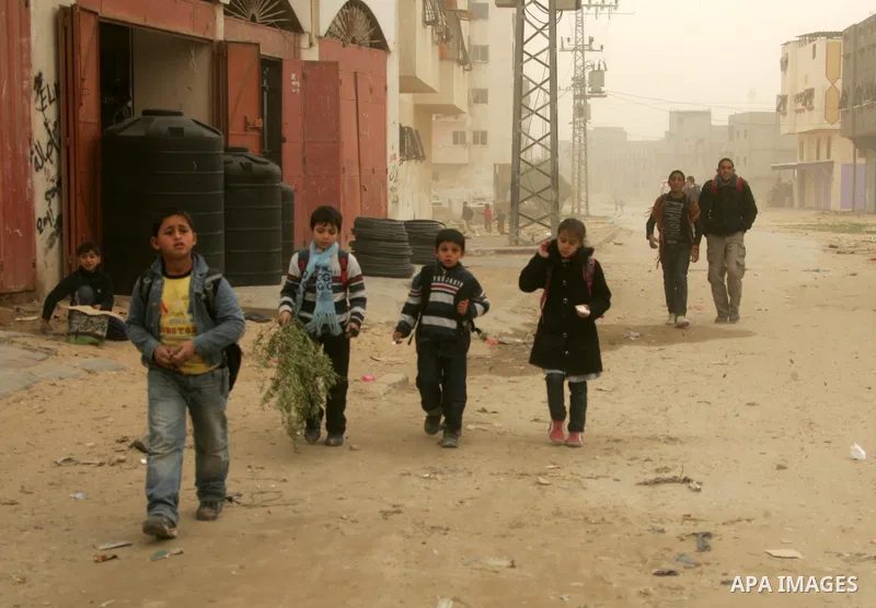 Palestinians walk at a street during cold winds and sand storms in the southern Gaza Strip town of Rafah on February 7, 2012. Photo by Abed Rahim Khatib
