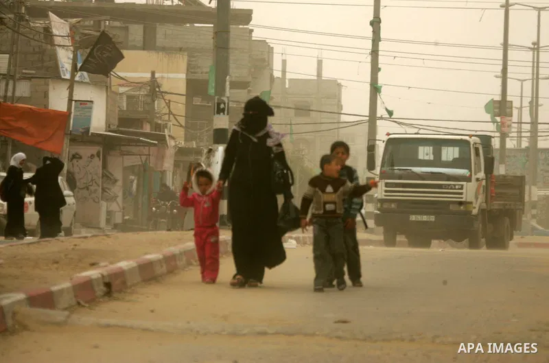 Palestinians walk at a street during cold winds and sand storms in the southern Gaza Strip town of Rafah on February 7, 2012. Photo by Abed Rahim Khatib