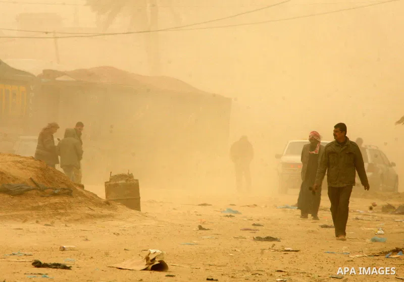 Palestinians walk at a street during cold winds and sand storms in the southern Gaza Strip town of Rafah on February 7, 2012. Photo by Abed Rahim Khatib