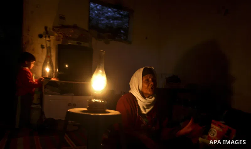 Em Sameer, 90, and her grandson are seen at candle light in a room of their home during an electricity power cut in the Jabaliya refugee camp, Gaza Strip, 07 February 2012. Electricity is reported to be cut for 12 hours...